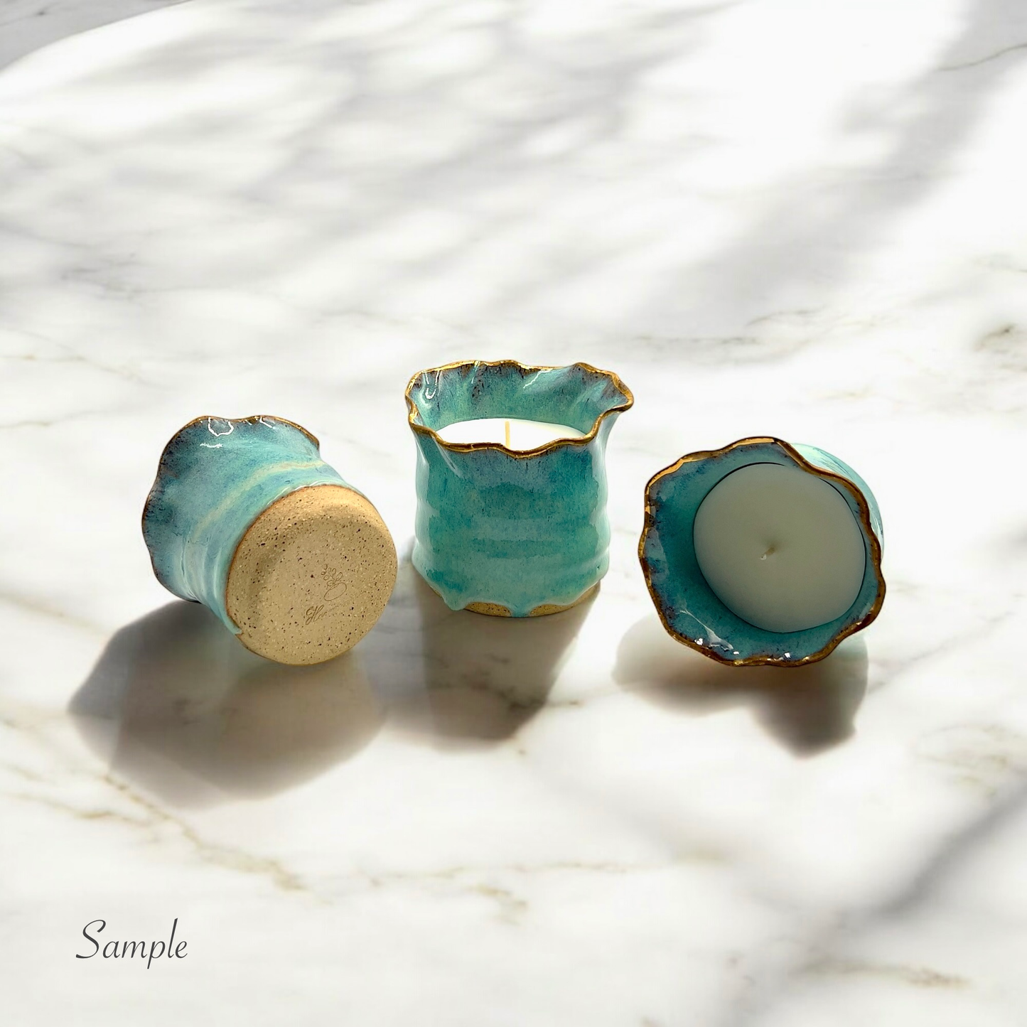 Handmade ceramic candle holders with a gold-rimmed edge, featuring an organic turquoise glaze. Filled with aromatic soy wax, these elegant candles make a perfect luxury gift for home decor lovers and special occasions
